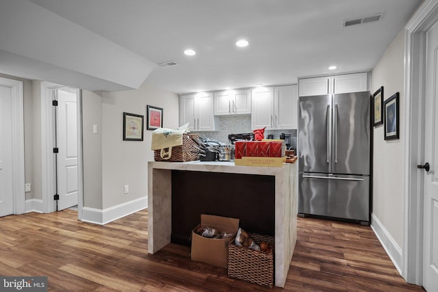 kitchen with white cabinets, dark hardwood / wood-style floors, and stainless steel refrigerator