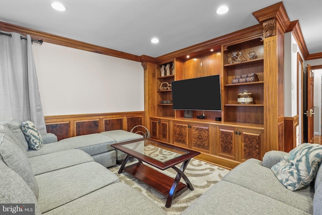 living room featuring built in shelves, wooden walls, and crown molding