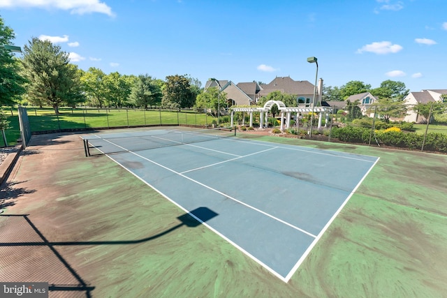 view of tennis court with a pergola