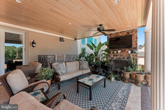 view of patio / terrace with an outdoor living space with a fireplace and ceiling fan