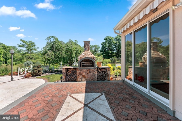 view of patio featuring an outdoor stone fireplace