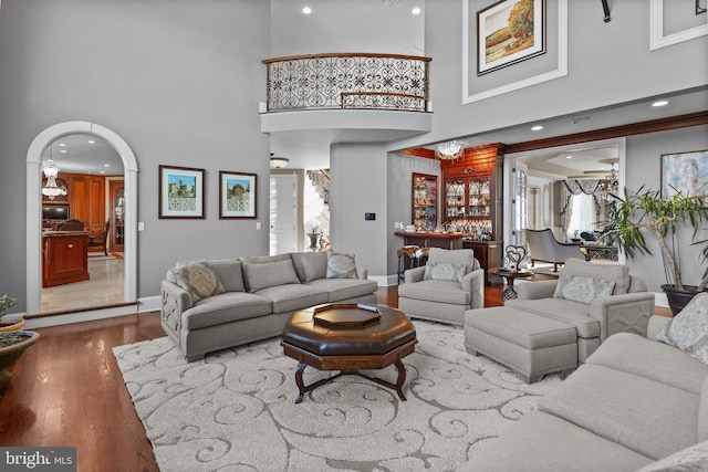 living room with a high ceiling, indoor bar, and hardwood / wood-style floors