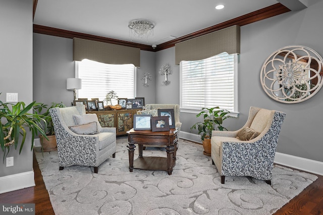 sitting room with hardwood / wood-style flooring and ornamental molding