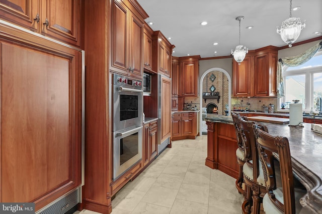 kitchen with backsplash, double oven, crown molding, decorative light fixtures, and light tile patterned flooring