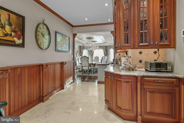 bar with backsplash, light stone countertops, light tile patterned floors, and ornamental molding