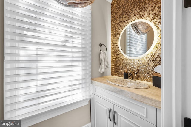 bathroom featuring vanity, backsplash, and a healthy amount of sunlight