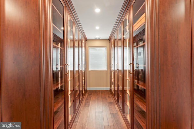 mudroom with wood-type flooring and crown molding