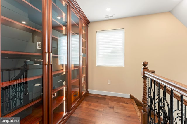 hall featuring dark hardwood / wood-style flooring and vaulted ceiling