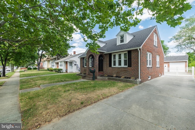 view of front of home with a garage, an outbuilding, and a front lawn