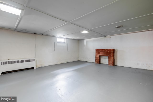 basement with a fireplace and radiator heating unit