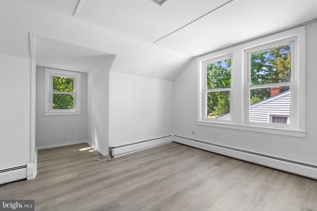 bonus room with plenty of natural light, light hardwood / wood-style floors, lofted ceiling, and baseboard heating