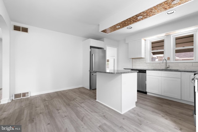 kitchen with a center island, white cabinetry, appliances with stainless steel finishes, and light hardwood / wood-style flooring