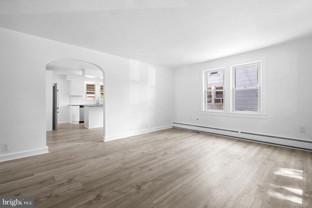 unfurnished room featuring light hardwood / wood-style flooring and a baseboard heating unit