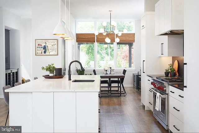 kitchen with dark hardwood / wood-style flooring, luxury range, sink, white cabinets, and hanging light fixtures