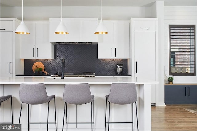 kitchen with pendant lighting, white cabinetry, and a kitchen breakfast bar