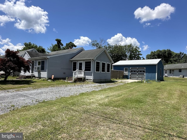 rear view of property featuring a lawn, an outdoor structure, and a garage