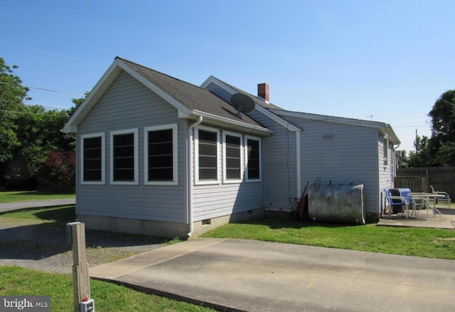 view of side of property featuring a yard and a patio area