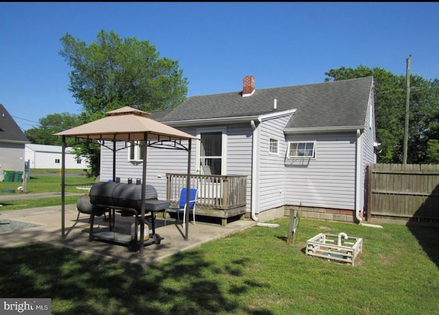 rear view of property with a gazebo, a lawn, a patio, and a deck