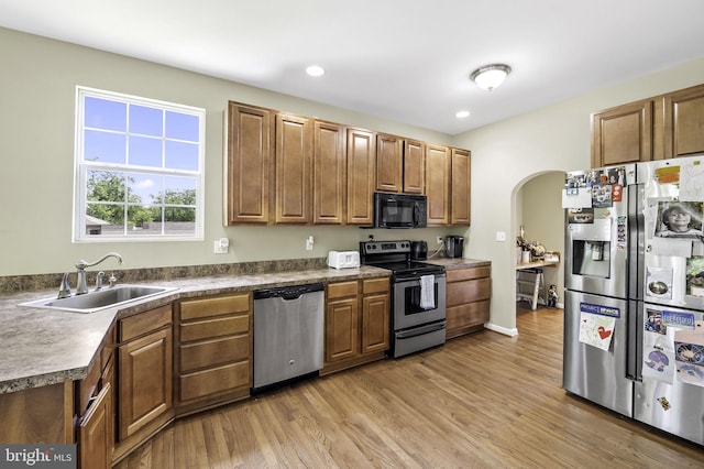 kitchen featuring sink, light wood-type flooring, and appliances with stainless steel finishes