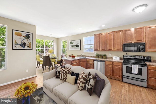 kitchen featuring sink, appliances with stainless steel finishes, decorative light fixtures, light hardwood / wood-style floors, and a chandelier