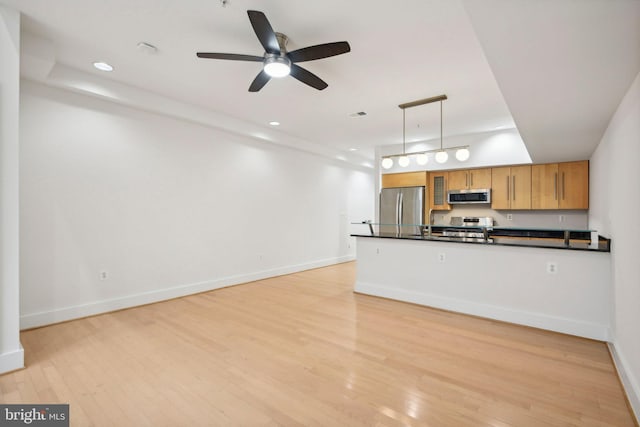 kitchen featuring ceiling fan, light hardwood / wood-style flooring, hanging light fixtures, and appliances with stainless steel finishes