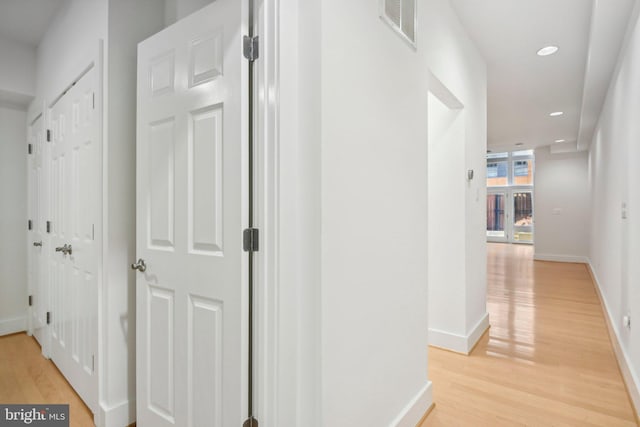 hallway with light hardwood / wood-style floors