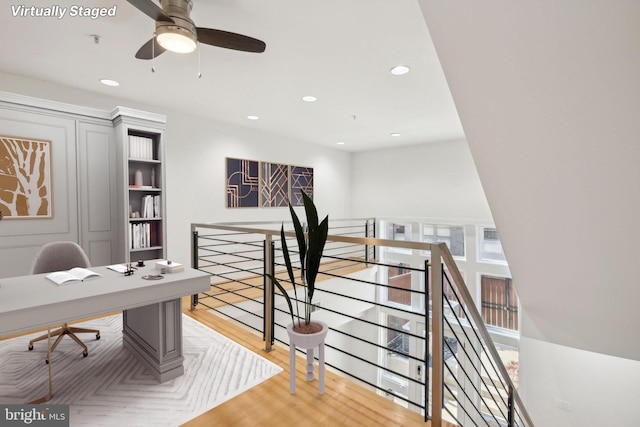 office with light hardwood / wood-style floors and ceiling fan