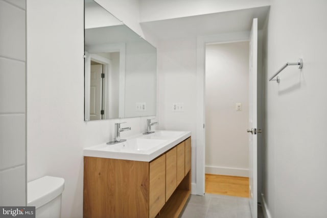 bathroom featuring tile patterned flooring, vanity, and toilet