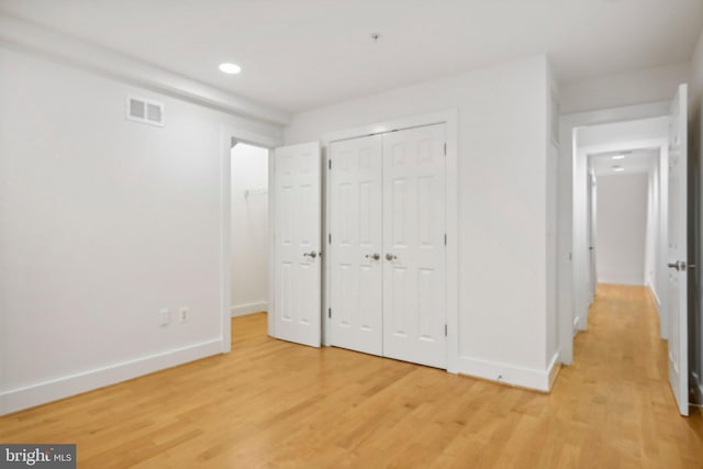 unfurnished bedroom featuring light wood-type flooring and a closet