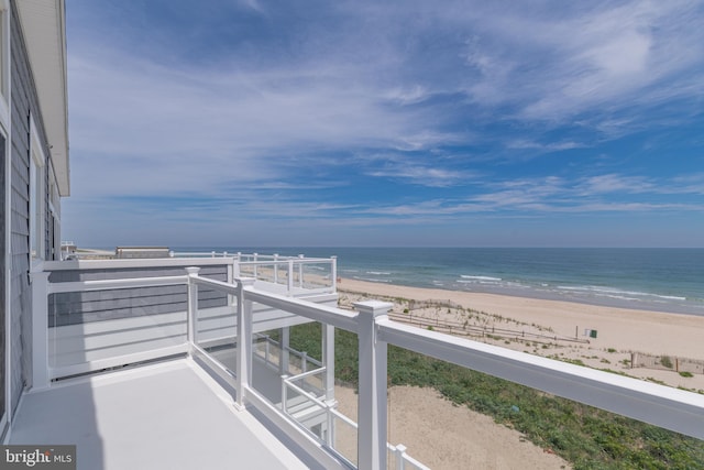 balcony featuring a water view and a beach view