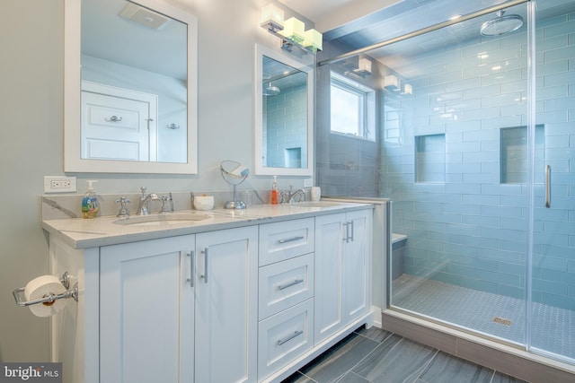 bathroom with tile patterned flooring, vanity, and a shower with door