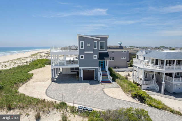 exterior space with a beach view, a water view, and a garage