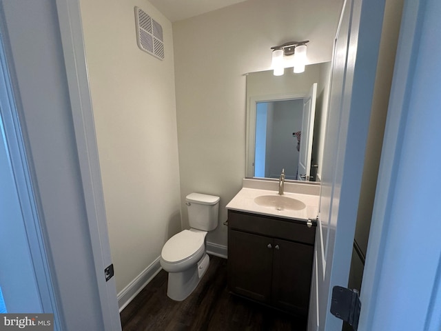 bathroom with vanity, toilet, and wood-type flooring