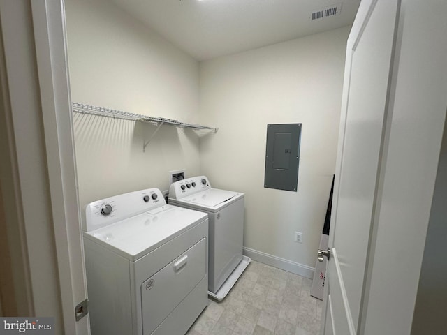 clothes washing area featuring electric panel and washer and clothes dryer