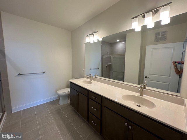 bathroom with tile patterned floors, vanity, an enclosed shower, and toilet