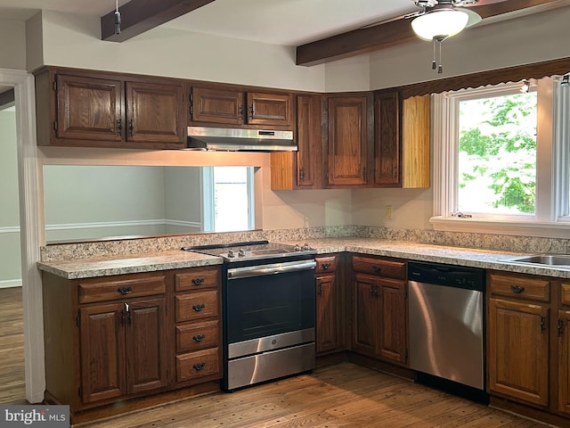 kitchen featuring beamed ceiling, wood-type flooring, stainless steel appliances, and ceiling fan