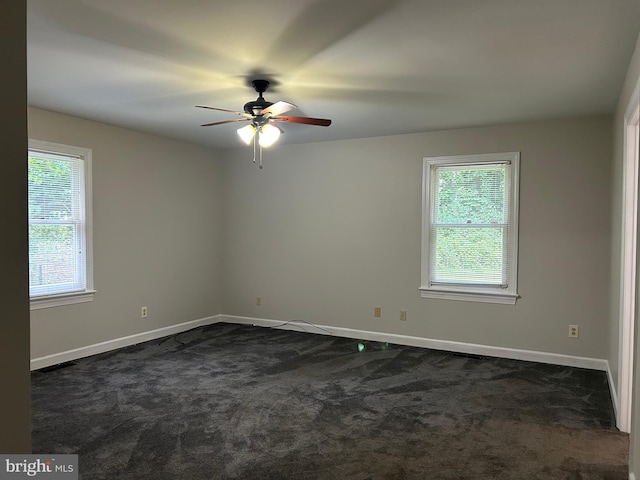 empty room with dark carpet and ceiling fan