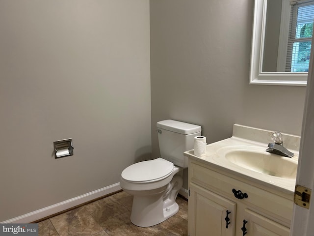 bathroom with toilet, vanity, and tile patterned flooring