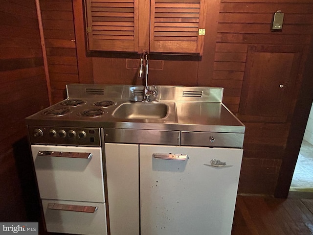 kitchen with dark wood-type flooring and wood walls