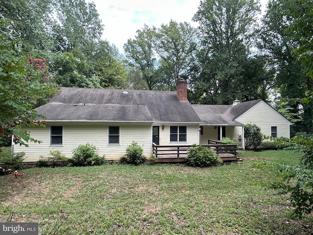 rear view of property with a wooden deck and a yard