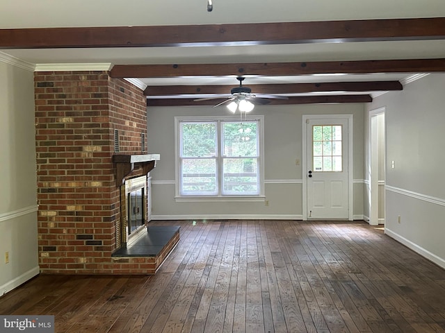 unfurnished living room featuring ceiling fan, beam ceiling, crown molding, dark wood-type flooring, and a brick fireplace