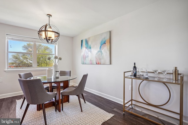 dining area with a notable chandelier and dark hardwood / wood-style floors