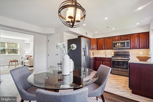 dining room with light hardwood / wood-style floors and an inviting chandelier