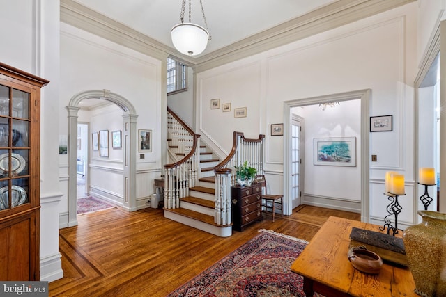 entrance foyer featuring ornamental molding, ornate columns, and dark hardwood / wood-style floors