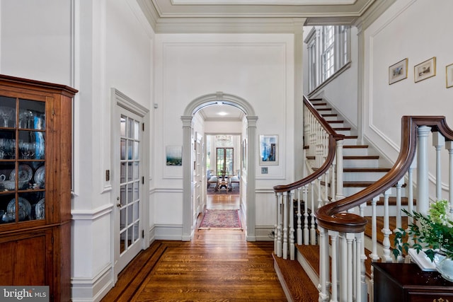 entryway with crown molding and dark wood-type flooring