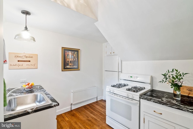 kitchen featuring lofted ceiling, dark wood-type flooring, sink, white range with gas stovetop, and white cabinetry