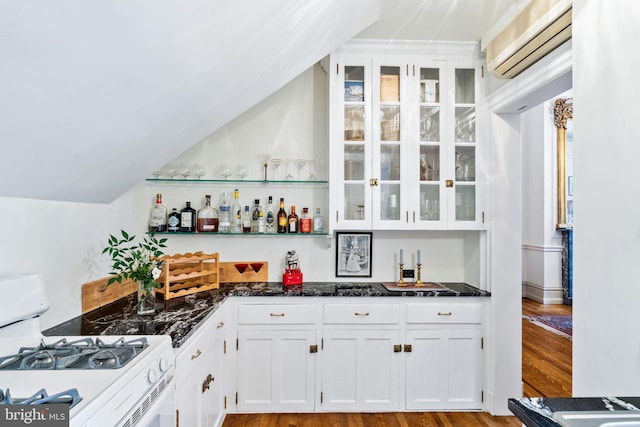 bar featuring an AC wall unit, white gas range, lofted ceiling, white cabinets, and light hardwood / wood-style flooring