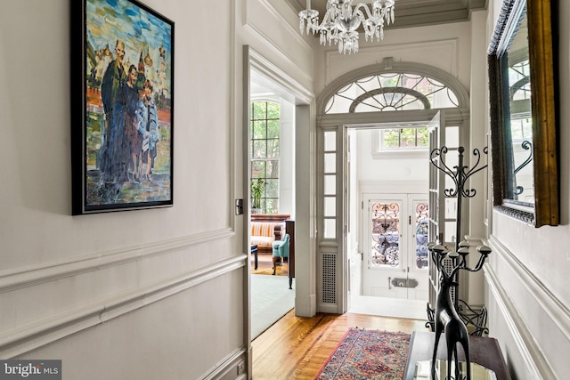 doorway to outside featuring french doors, light hardwood / wood-style floors, and an inviting chandelier