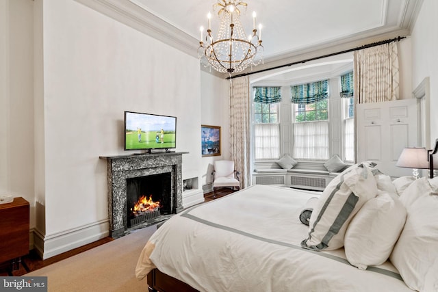 bedroom featuring a premium fireplace, crown molding, a notable chandelier, and wood-type flooring