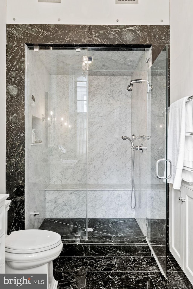 bathroom with toilet, vanity, tile walls, and a shower with door